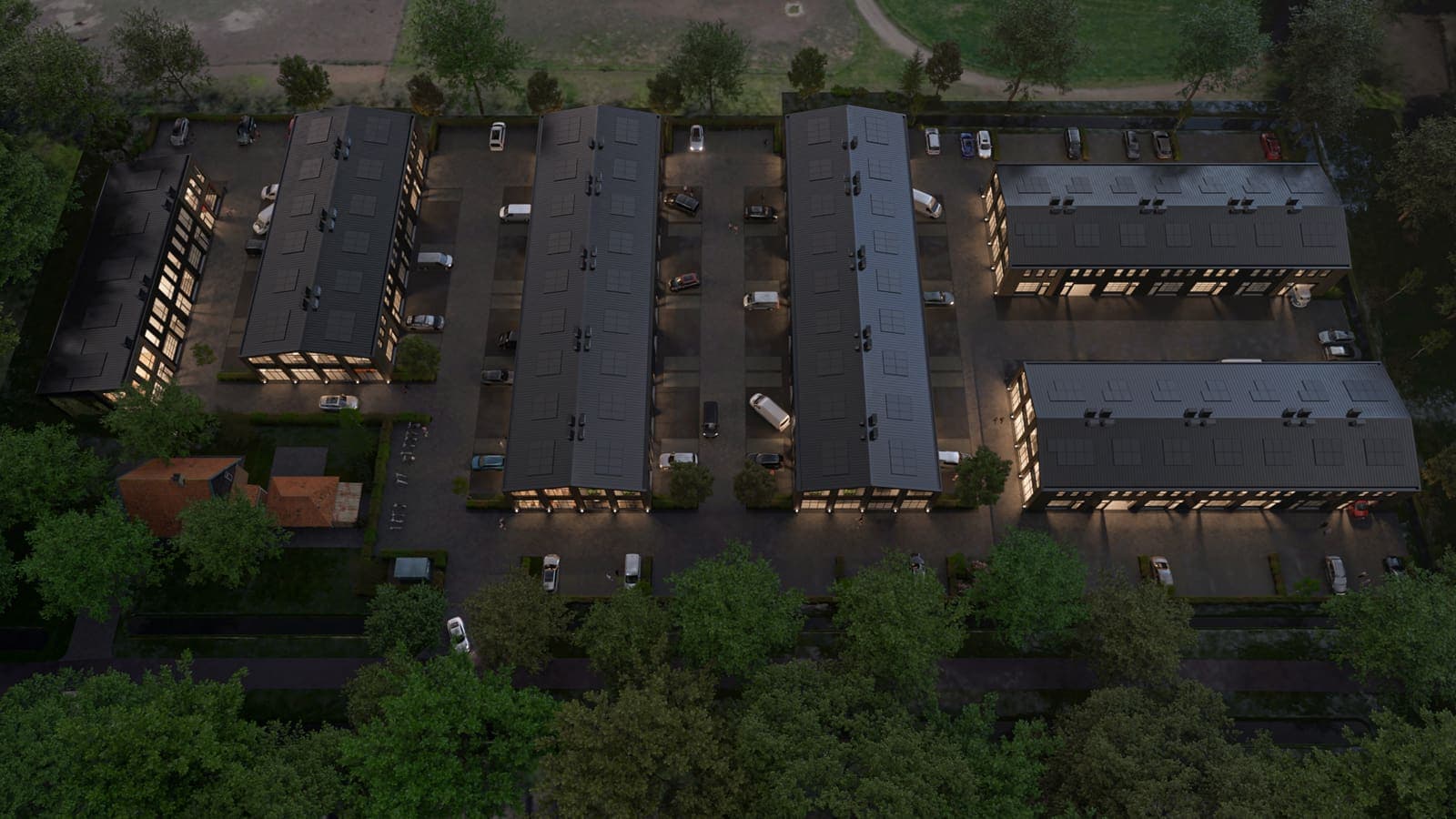 Luchtbeeld in de schemering van bedrijfsunits met verlichte gevels, voor Businesspark Soest