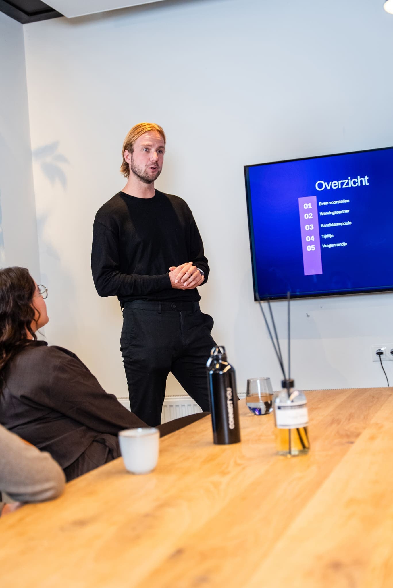 Man geeft een presentatie bij een scherm met agenda, voor ConnectYou
