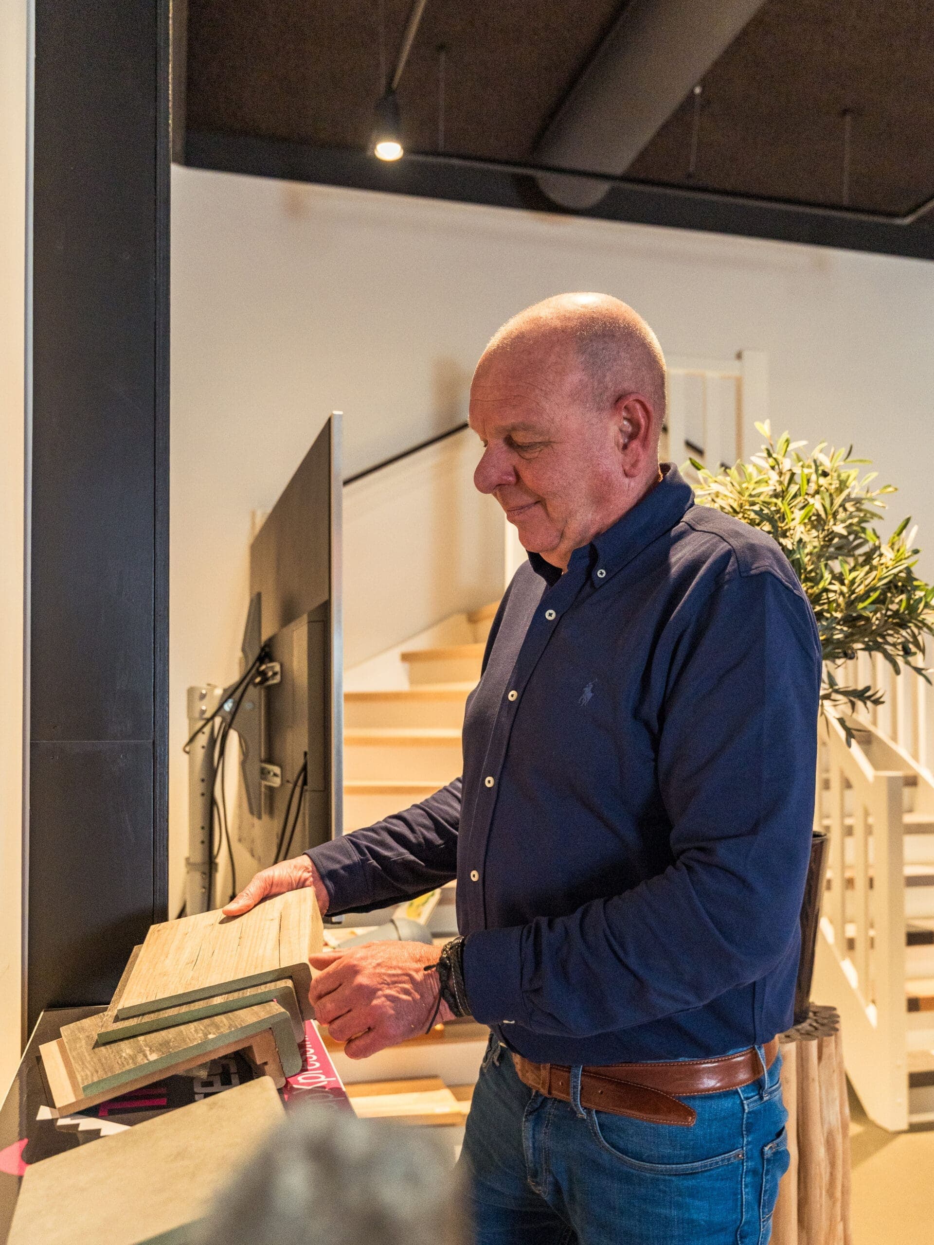 Man bekijkt trapbekleding in de showroom van TrapXpress