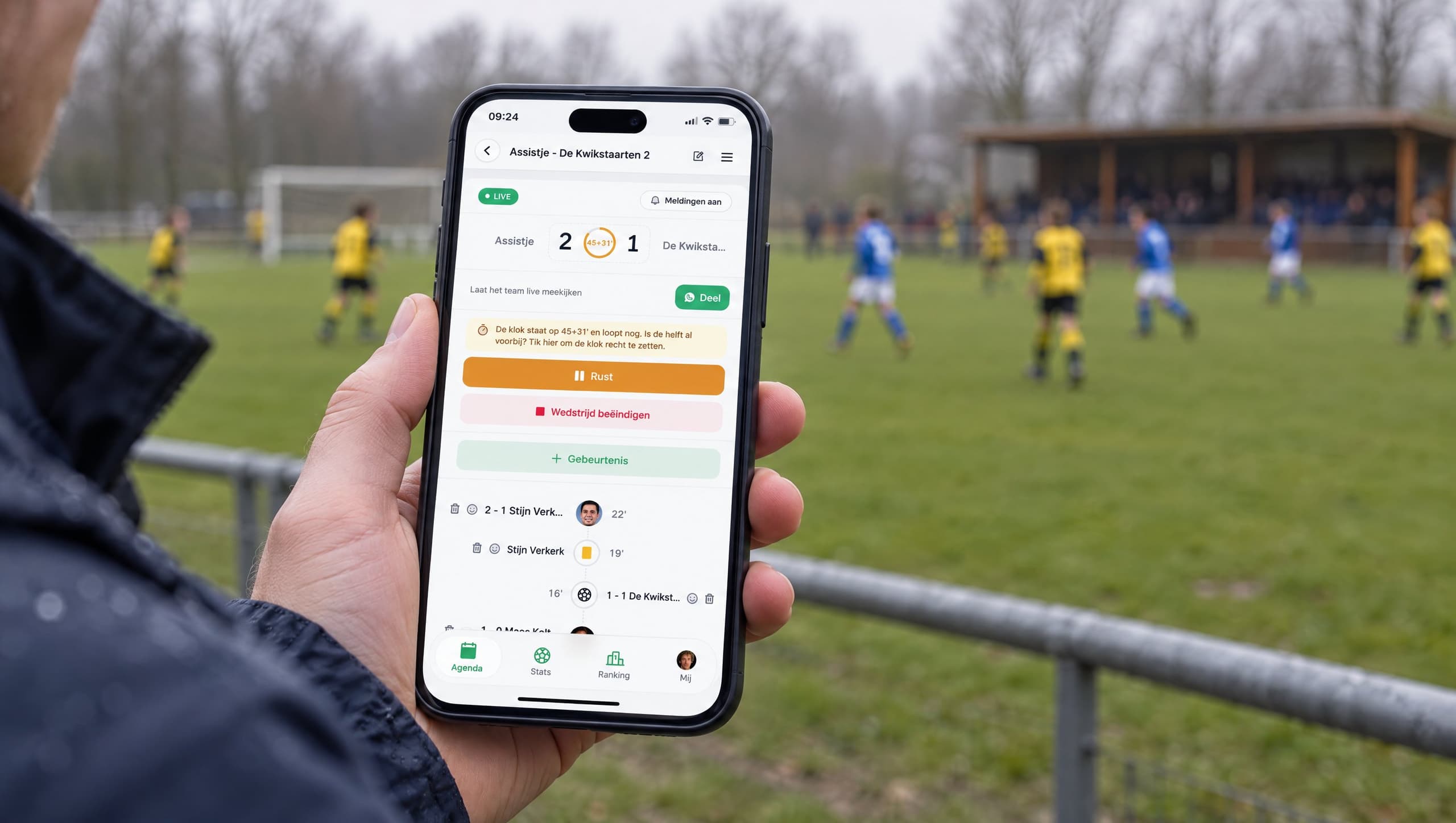 Een ouder volgt de wedstrijd live in Assistje vanaf de zijlijn